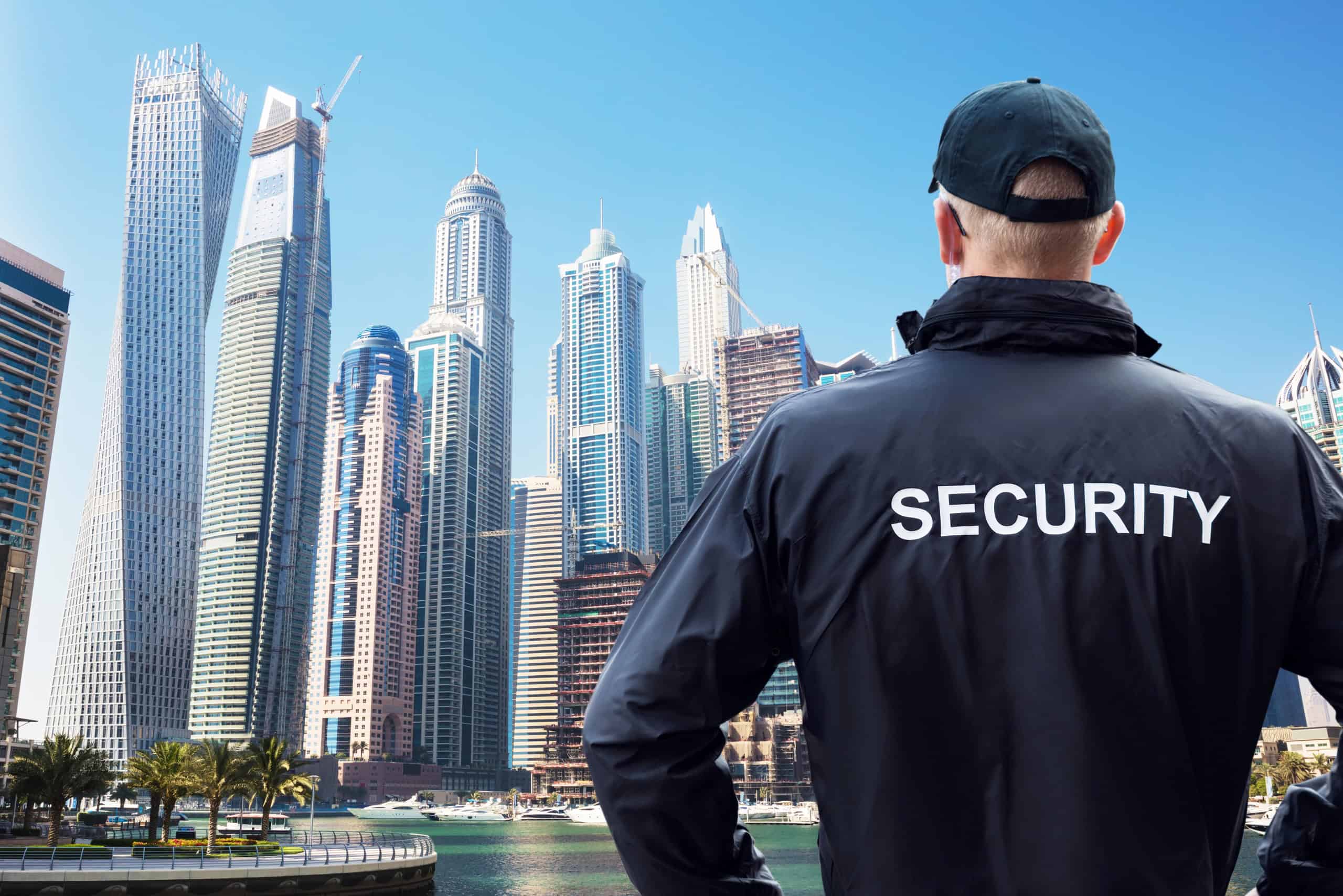 Security guard with back turned looking at Dubai skyscraper skyline. Concept for Dubai safety.